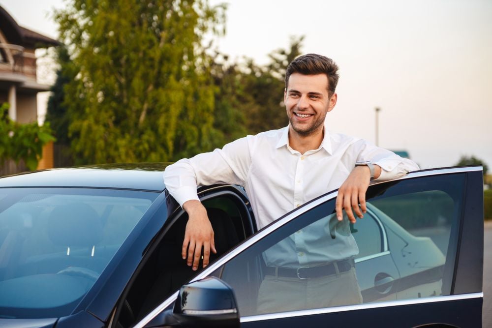 man stapt in auto