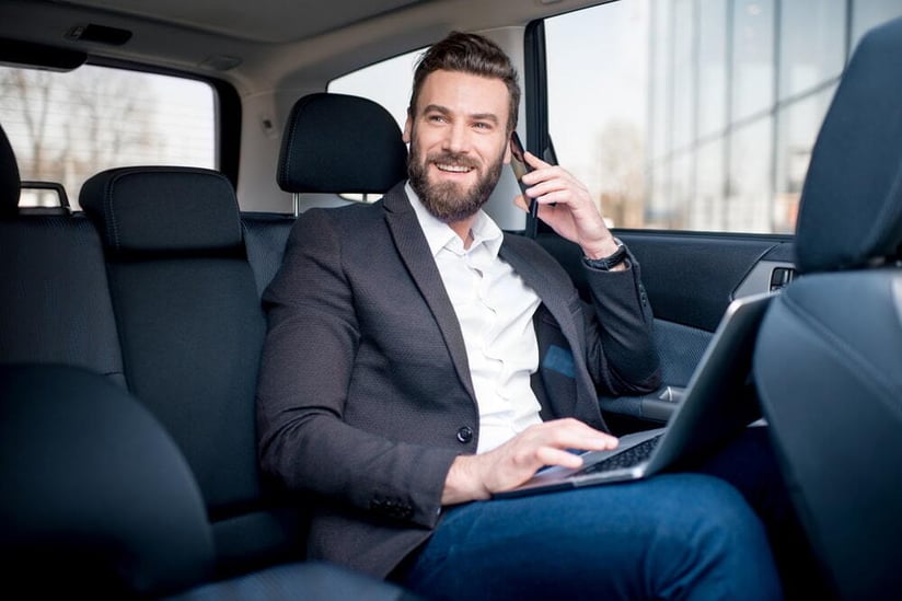 Business man in car on cell phone for international business